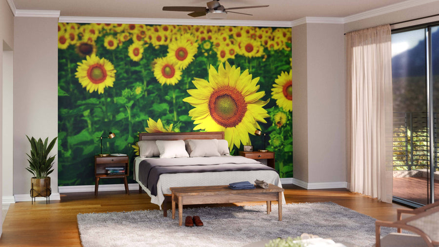 A modern open-plan living and dining area with wood floors and furniture features the Beautiful Sunflowers Wall Mural, a vibrant peel and stick design of blooming sunflowers on a green background that creates a cheerful focal point.