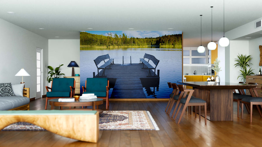 Open-plan living and dining area with wooden floors, blue-green chairs, and the Benches by the Water Wall Mural featuring a lakeside dock, calm water, and trees. Natural light and modern decor complete this inviting space.