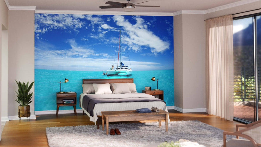 A modern living-dining room with wood floors and furniture features the Bora Bora Blue Lagoon Wall Mural on the back wall, depicting a catamaran on turquoise sea for an ocean view illusion in a bright, stylish, and contemporary space.