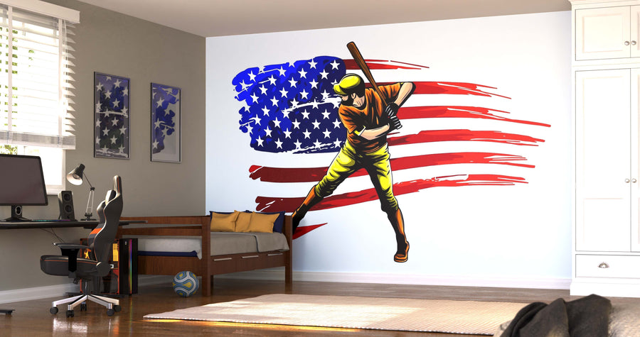 A modern bedroom showcases the Baseball Art Wall Mural with a player swinging a bat before a stylized American flag, complemented by a desk, chair, bed, soccer ball, framed art pieces, and sunlit window blinds.