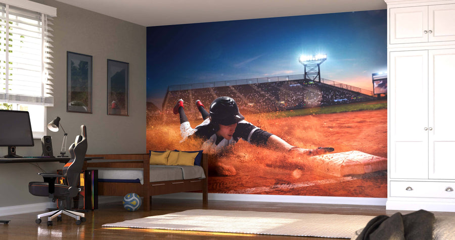 A bedroom with a bed, desk, and chair features the Baseball Player Wall Mural showing a player sliding into base under stadium lights. The room also has a soccer ball, framed wall art, and removable murals for easy updates.