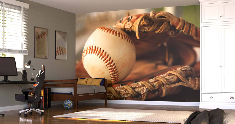 A bedroom with a desk, computer, daybed, built-in wardrobes, and sunlight filtering through the blinds. The wall is decorated with a striking Baseball and Glove Wall Mural. A soccer ball rests under the bed.