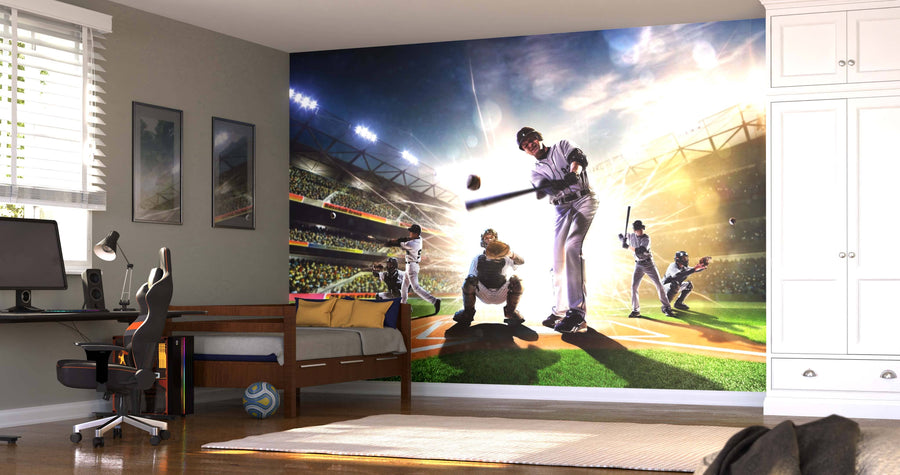 A modern bedroom features the Big Hit Wall Mural, a vibrant peel and stick mural of a baseball game with a batter, catcher, umpire, and fielders. The room also has a bed, desk with chair, computer, sports ball, and bright natural light.