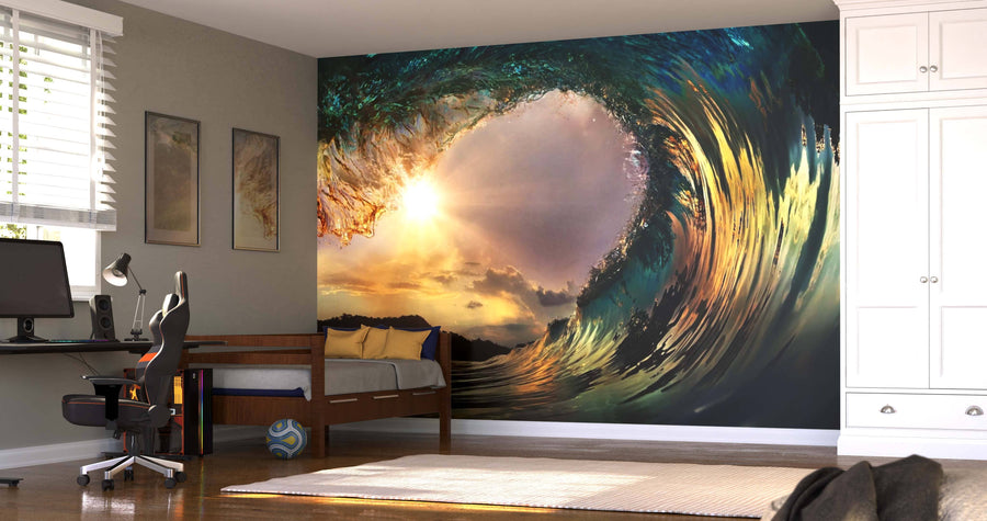 A modern bedroom showcases the Breaking Point Wall Mural, depicting a sunlit wave curl. The space includes a bed, desk with computer, chair, striped pillows, white wardrobe, and sunlight filtering through window blinds.