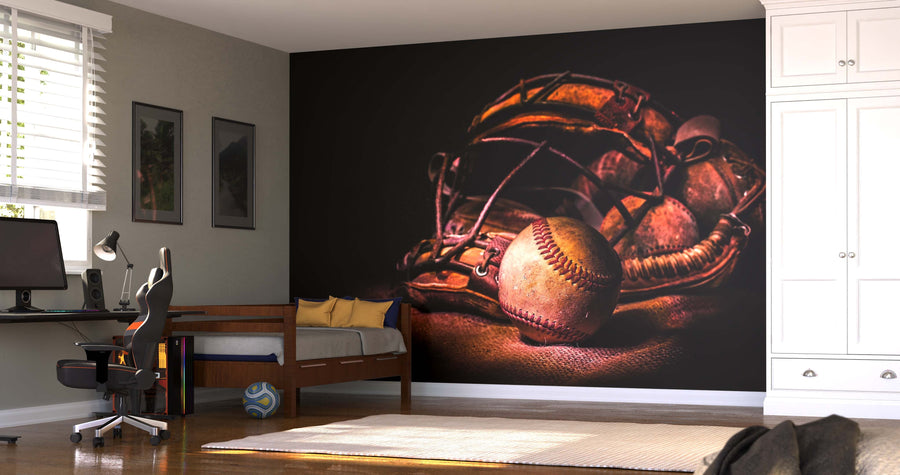 A modern bedroom features the Catcher's Mask With Baseball Wall Mural, a desk with a computer, a bed with a blue blanket, framed wall pictures, and a soccer ball on the floor.