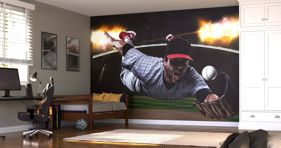 A modern bedroom with a desk, bed, and wardrobe is highlighted by the Catching Baseball Wall Mural, showing a player in a black cap and striped uniform diving for a ball under bright stadium lights.