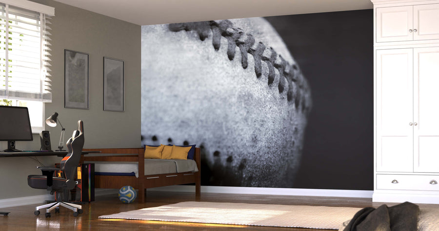 A modern bedroom features a desk, computer chair, bed, and wardrobe. The highlight is the Closeup of Old Rustic Baseball Wall Mural in black and white. Sunlight through blinds creates shadows on the light-colored floor.