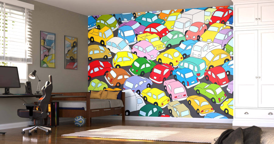 A bedroom with a computer desk, bed, white cabinet, striped pillow, soccer ball, and framed abstract art is enlivened by the Colored Traffic Jam Wall Mural—a vibrant custom print of overlapping cars covering an entire wall.