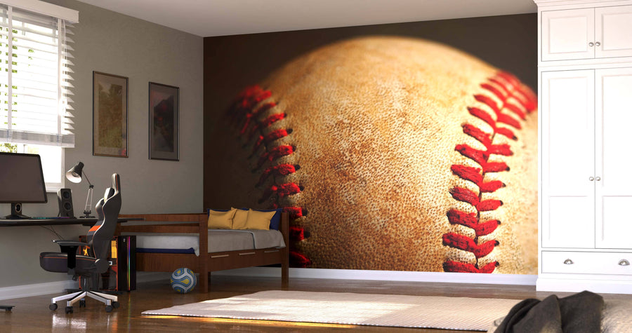 A modern bedroom features a desk, chair, bed, white cabinets, and the Dirty Baseball Wall Mural as a striking backdrop. Sunlight comes through blinds by framed pictures, while a soccer ball lies on the floor.