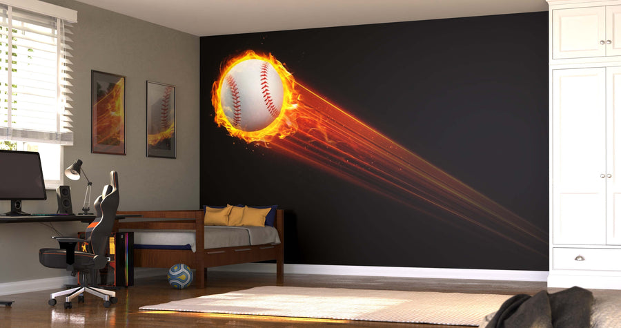A modern bedroom with a black accent wall displays the Flying Baseball Wall Mural, showing a flaming baseball streaking across. The room includes a desk, office chair, single bed with pillows, soccer ball, framed art, and white cabinetry with sunlight streaming in.