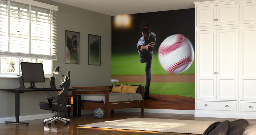 A modern bedroom showcases the Pitcher Throwing Baseball Wall Mural, with a bed, computer desk, office chair, framed pictures, a soccer ball on the floor, and sunlit windows completing the sporty space.
