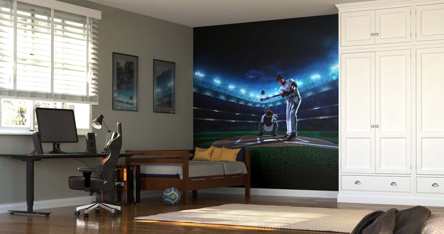 A modern bedroom with a desk, computer, and bed features the "Swing to Win Wall Mural," a dramatic matte canvas textured peel and stick design of a nighttime baseball scene. Sunlight filters in, and a soccer ball rests on the wooden floor.
