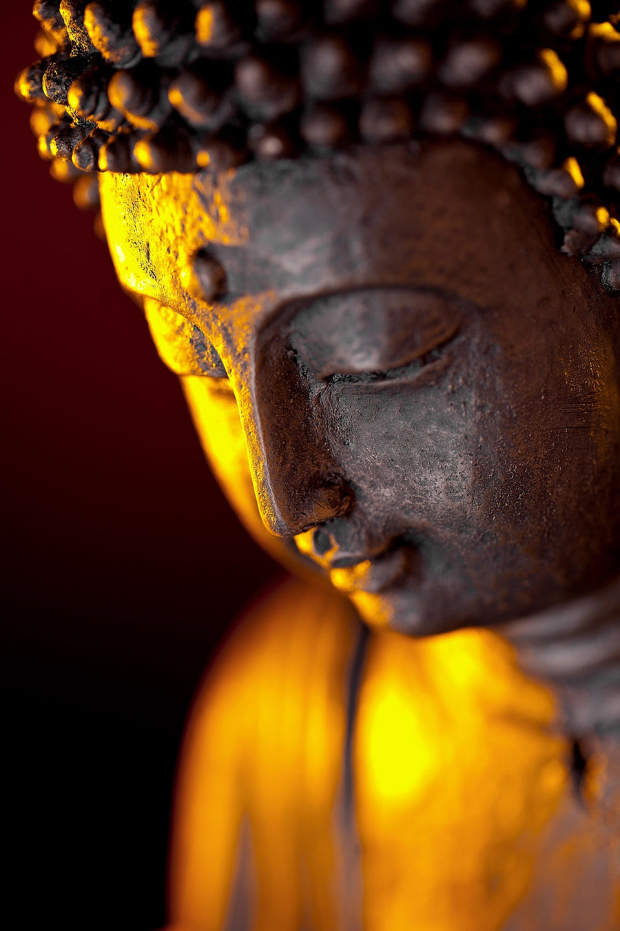 A modern living space features a dining area with wooden furniture, sheer curtains, and decor. The Buddha Zen Orchidee Statue Gott Wall Mural adds a serene touch, displaying a peaceful bronze Buddha softly lit for a calming atmosphere.