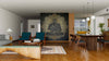 A modern open-plan living and dining room features wooden floors, teal chairs, a wooden dining table, and a striking black wall with the Buddha Sitting in Lotus Position Wall Mural. Pendant lights hang above the table, with the kitchen visible in the background.