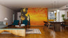 A modern living-dining room with wooden flooring, teal chairs, a rug, and a wooden dining table features the "Buddha Statue on Golden Patterns Wall Mural" as a striking accent. The kitchen can be seen in the background.