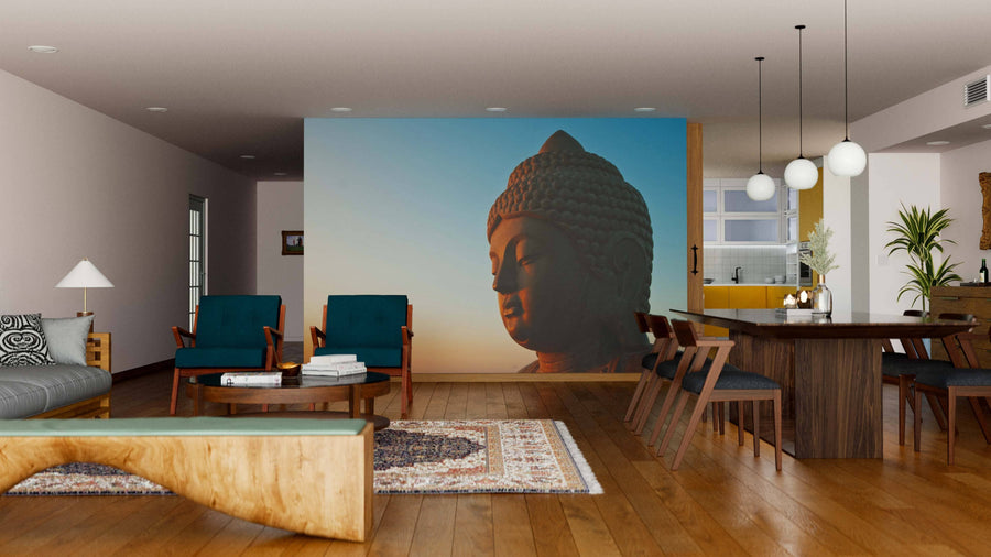 A modern living-dining room with wooden floors, chic furniture, and a large "Buddha at Sunrise Wall Mural." Warm lighting, rugs, pendant lights, houseplants, and contemporary-natural decor complete the serene atmosphere.