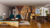 A modern living-dining area with wooden floors, teal chairs, and a rug features the "Buddhas in Wat Pho Temple Wall Mural" along one wall. Spherical pendant lights hang above the table, with kitchen views in the background.