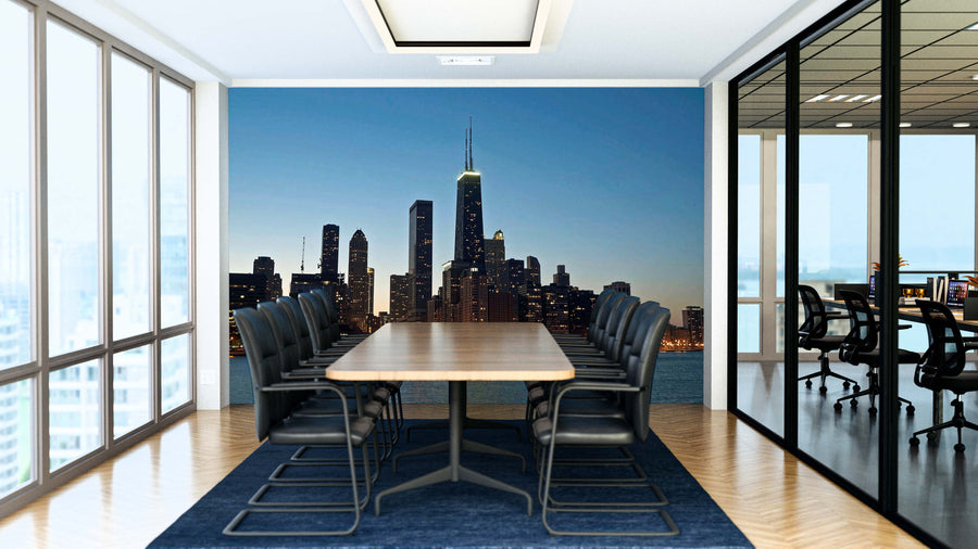 A modern conference room with a long wooden table, black chairs, and a large window wall featuring the Chicago Hancock at Night Wall Mural. Glass walls show another office area; the floor is light wood with a dark blue rug.