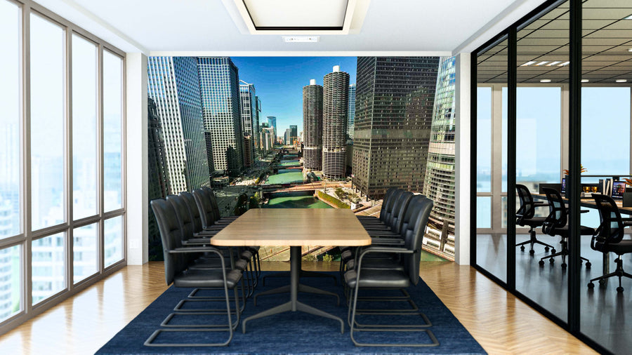 A modern conference room features a long wooden table, eight black chairs, glass walls, and a Chicago River Marina Towers Wall Mural. Natural light fills the space with another office visible through the glass.