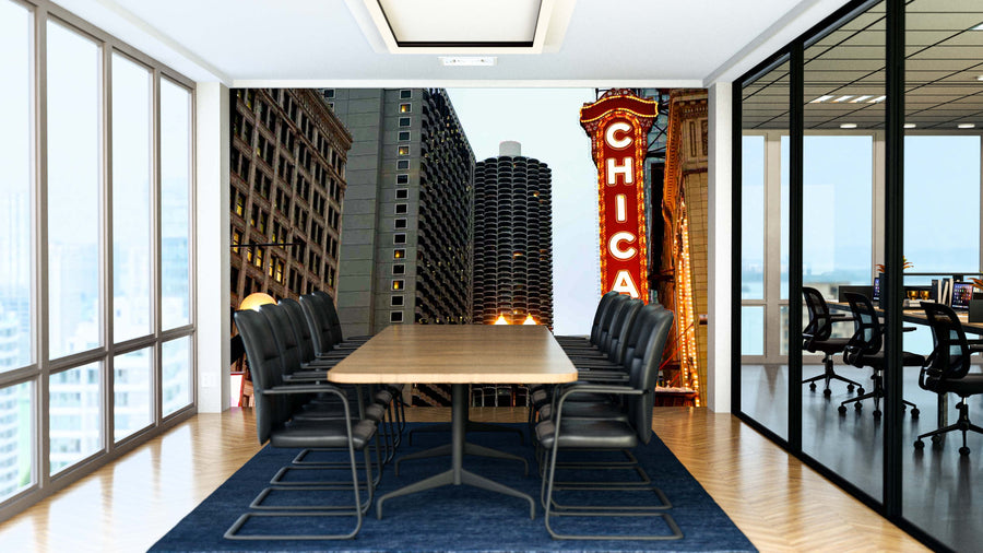 A modern conference room with black chairs around a long wooden table features floor-to-ceiling windows, city views, and one wall covered by the Chicago Theater Sign Wall Mural. Glass walls separate it from adjacent offices.
