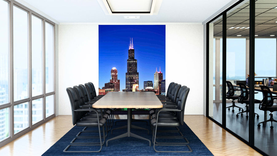 A modern conference room with a long table, black chairs, and a large Chicago Willis Sears Tower Wall Mural. Glass walls reveal an adjacent office space and the city skyline outside.
