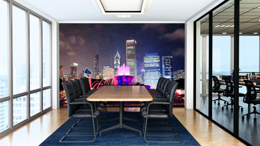 A modern conference room with a long wooden table, black chairs, and glass walls. The back wall features the Chicago Buckingham Fountain Wall Mural—a colorful peel-and-stick city skyline at night with lit buildings and a vibrant fountain.