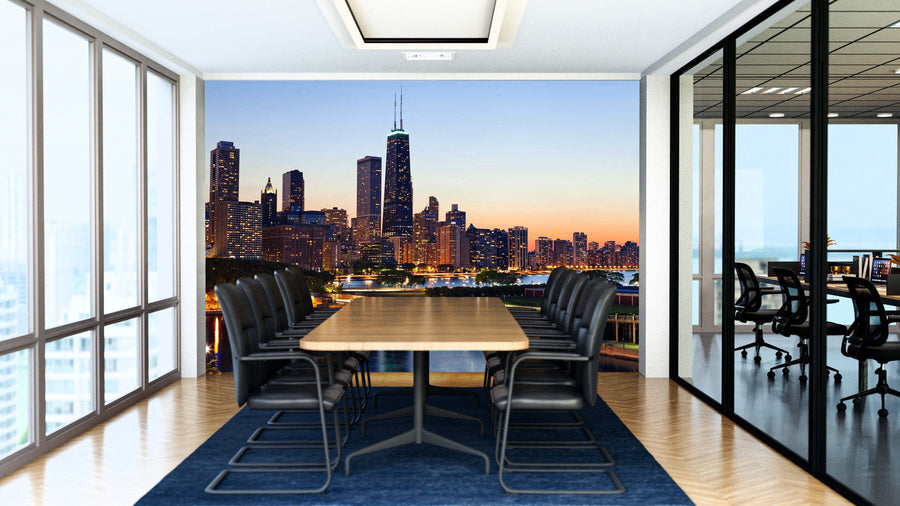 A modern conference room with a long wooden table, black chairs, glass walls, and the Chicago Dusk at Belmont Harbor Wall Mural featuring a city skyline at sunset. Bright natural light streams in from large windows on the left.