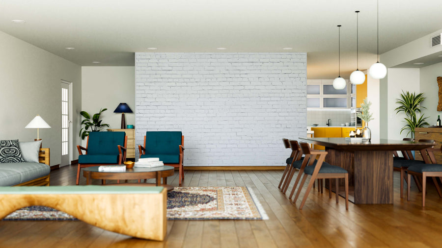 A spacious, modern living and dining area with wooden floors. The Clean Brick Surface Wall Mural creates a chic accent, complemented by teal armchairs, a gray sofa, plants, a long wood table with mid-century chairs, and pendant lights.