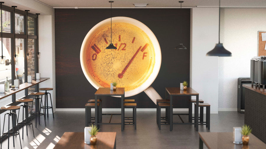 A modern café with wooden tables and black chairs features the Caffeine Fuel Wall Mural—a coffee cup as a fuel gauge. Pendant lights hang overhead, and plants on the tables add warmth to the inviting space.