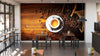 A modern café interior features tables, stools, large windows on the left, small plants, and a cozy custom-printed Espresso and Coffee Beans Wall Mural that adds warmth and charm to the inviting space.