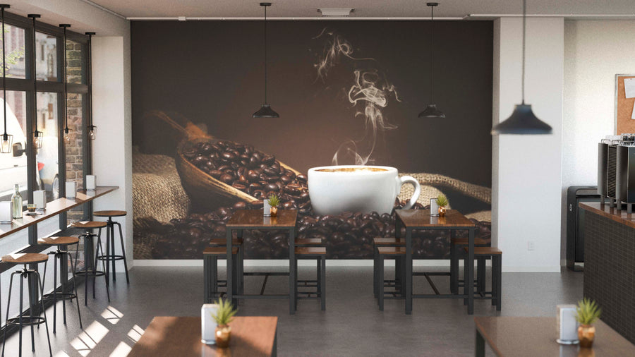 A modern café interior with wooden tables, chairs, potted plants, and black pendant lights. The back wall displays the "Roasted Beans and Wooden Scoop Wall Mural," enhancing the cozy atmosphere.