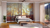 A cozy bedroom with a large bed, bedside tables, lamps, and a wooden bench. The focal wall displays the Colorful Autumn Leaves Wall Mural. There’s a plant, soft rug, ceiling fan, and glass doors with sheer curtains.