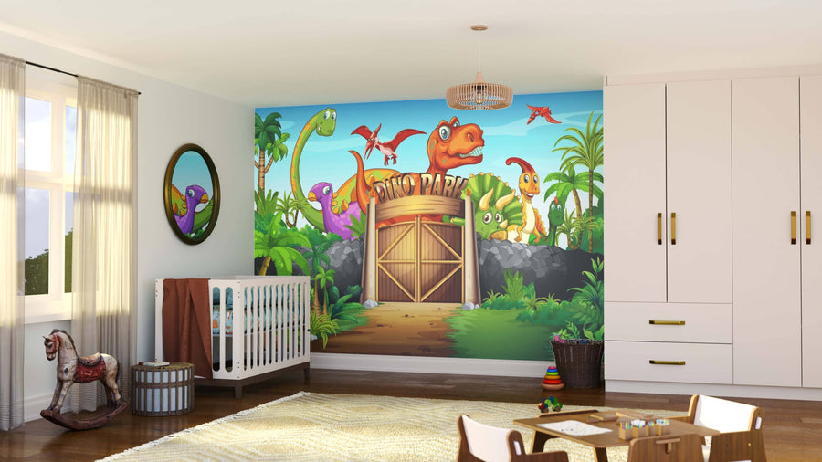 A cheerful kids' room showcases the Dino Park Wall Mural, a large, colorful peel-and-stick mural with cartoon dinosaurs and a "Dino Park" gate. The space includes a crib, rocking horse, mirror, toys, white furniture, and beige curtains with sunlight.