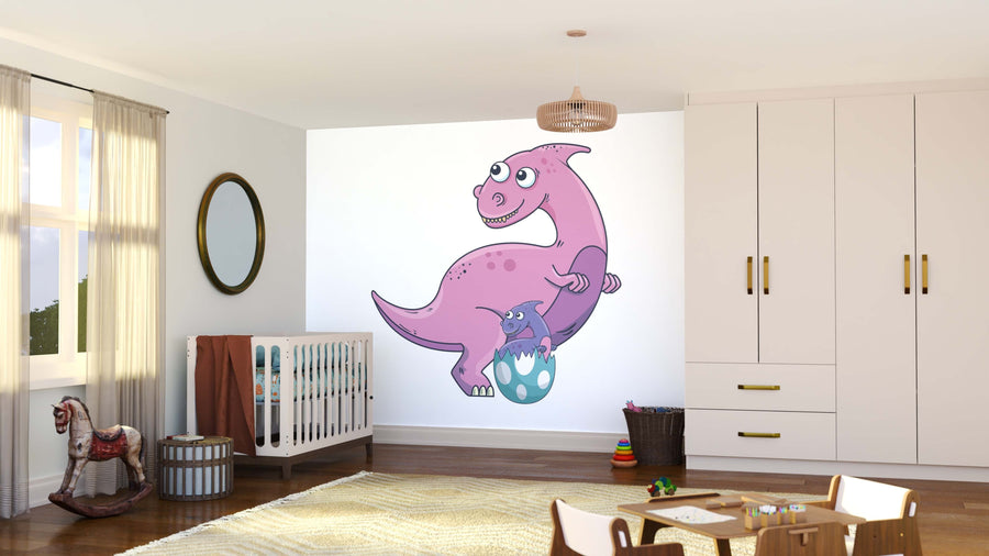 A bright nursery with white walls and wood floors features the playful Dinosaur Family Wall Mural showing a smiling pink dinosaur with a hatching baby. A white crib, wardrobe, mirror, rocking horse, and toys complete the cozy space.