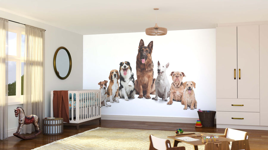 A bright nursery with a crib, rocking horse, and toys features the Dog Squad Wall Mural—seven dogs in a row on white removable wallpaper—on the back wall. Light streams through a window dressed with beige curtains.