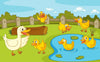 The Ducklings at Play Wall Mural features a white mother duck and five yellow ducklings outdoors, with two in a pond, three on grass, a wooden fence, green bushes, and a blue sky with clouds in the background.