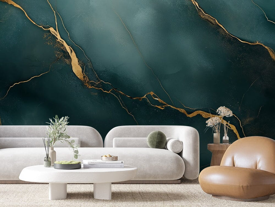 A modern living room displays two white, curved sofas and a tan, rounded chair centered around an oval coffee table with small plants. The Eclipse Marble Wall Mural adds a green and gold abstract design to the wall. A side table with dried flowers sits beside one sofa.