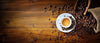 The Espresso and Coffee Beans Wall Mural features a white espresso cup on a saucer with coffee beans on a wooden table, bringing rustic charm and rich brown tones to your space—perfect as a custom printed or peel and stick wall mural.