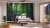 A modern bedroom with the "Fallen Leaves on the Road Wall Mural" behind the bed, neutral walls, wooden furniture, a gray rug, potted plants, sliding glass doors with sheer curtains, and sunlight streaming in.