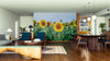 Modern open living-dining area with wooden floors, mid-century furniture, and the vibrant Field of Sunshine Wall Mural of sunflowers as a focal point. Warm lighting, blue armchairs, and eclectic rugs create a cozy, stylish, and inviting space.