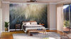 A modern bedroom features a large bed with white bedding, nightstands with lamps, a potted plant, and a soft rug. Behind the bed, the Foggy Forest with Sun Rays Wall Mural adds depth, while glass doors open to a balcony.