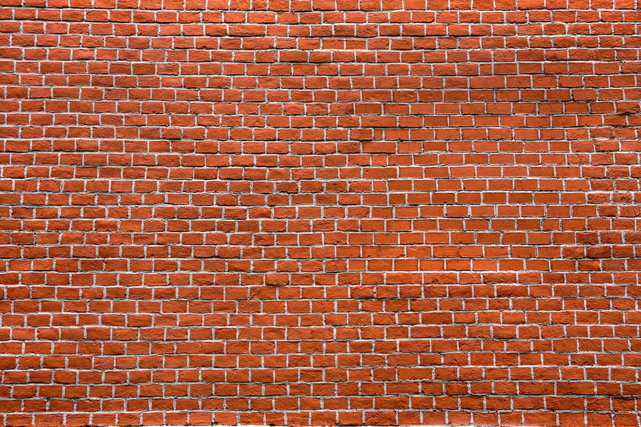 Modern open living and dining room with wood floors, teal chairs, sofa, wooden dining set, globe lights, yellow kitchen cabinets, plants and lamps for warmth, plus a custom Red Brick Pattern Wall Mural accent wall.