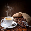 A steaming cup of coffee on a saucer with a spoon sits amid spilled beans—a cozy scene featured in the Coffee 6 Wall Mural, perfect as a custom print or peel and stick mural to warm up your space.