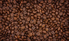 The Fresh Whole Beans Wall Mural features a close-up of shiny, dark brown roasted coffee beans with rich texture and glossy surfaces—perfect for creating a striking accent wall with easy peel and stick application.