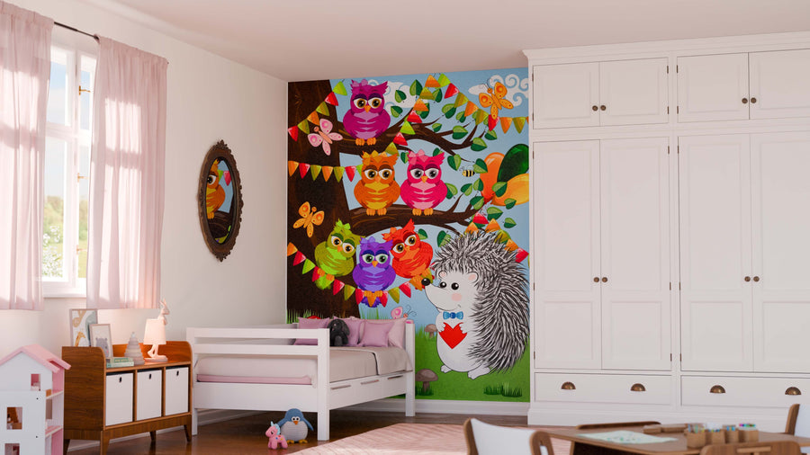 A bright kids' bedroom showcases the Owls and Hedgehog Wall Mural with colorful owls, a hedgehog holding a red heart, bunting, butterflies, and leaves. Removable wallpaper, pink bedding, a dollhouse, and soft pink curtains complete the décor.