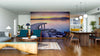 A modern open-plan living and dining room features wooden floors, blue armchairs, a unique bench, and the Golden Curve Wall Mural. Pendant lights, rugs, and plants add warmth to this stylish space.