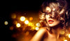 A glamorous woman with curly golden hair and bold red lipstick, partially hidden by her hair, stands against a backdrop that mimics Sexy 4 Wall Mural's golden bokeh lights. This creates a warm, luxurious vibe and her bare shoulders complete the elegant, fashionable look.