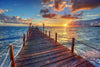 The Pier 1 Wall Mural depicts a serene wooden pier stretching into a vast ocean during a vibrant sunset, with orange and pink hues gracing the partially cloudy sky. Rope railings add to the tranquil scene as the sun nears the horizon, casting calming reflections on the water.