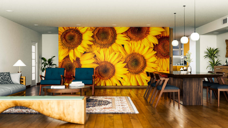 A modern living-dining room features a bold accent wall with the Golden Petal Array Wall Mural. Wooden floors, blue and wood furniture, globe lights, indoor plants, a patterned rug, and natural light complete the look.