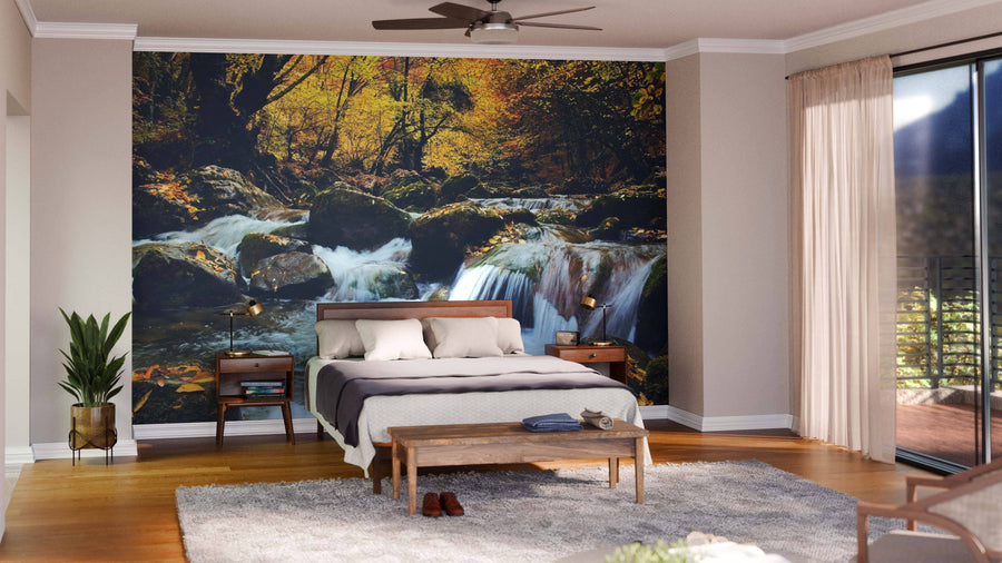 A bedroom showcases the Grand Canyon of Crimea Wall Mural behind a wooden bed with white and gray bedding. Nightstands with lamps, a potted plant, shaggy rug, wooden bench, and sheer-curtained glass doors complete the airy look.
